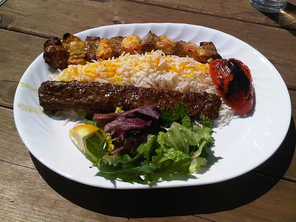 A Persian table spread of kababs, rice and stews